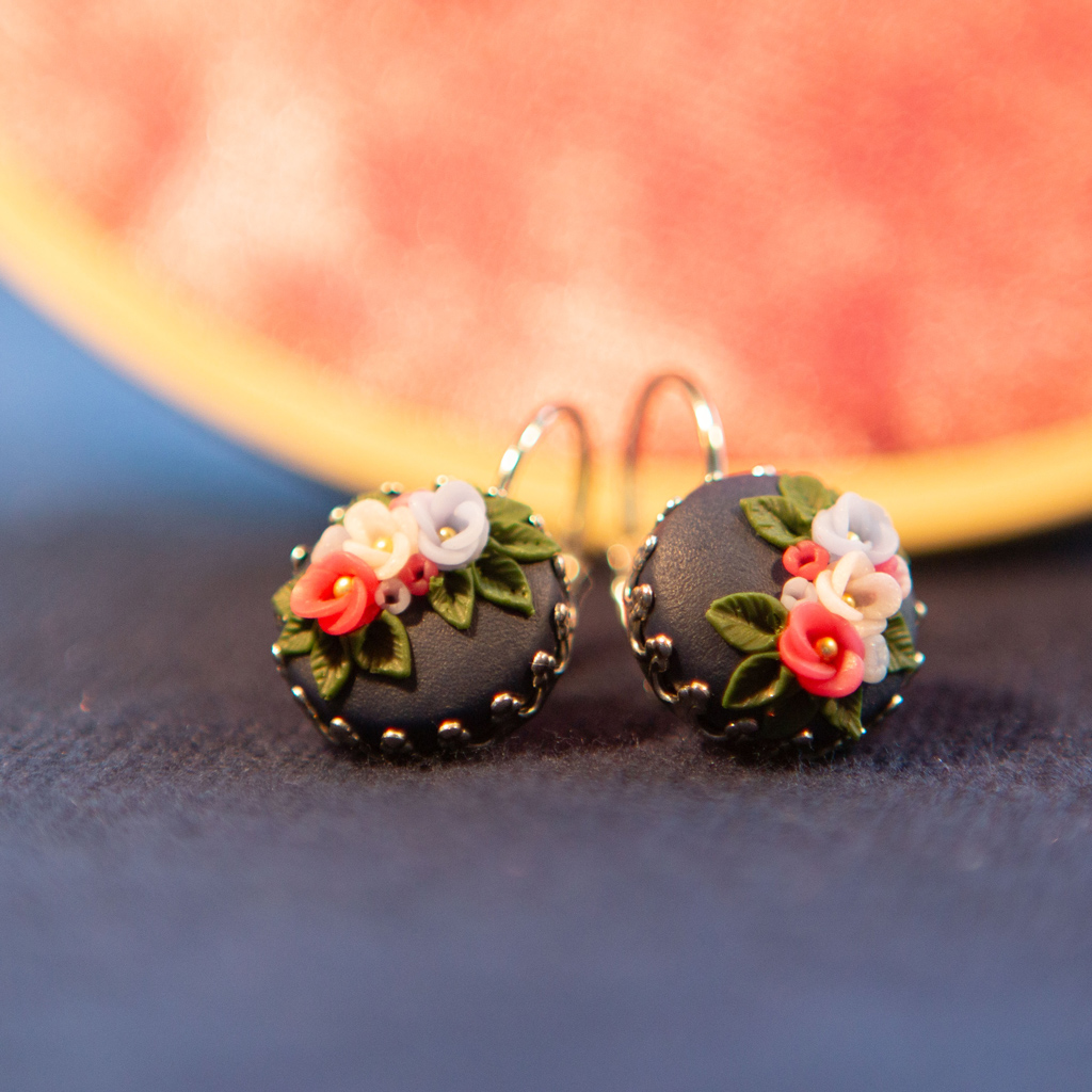 Ohrringe in Edelstahlfassung mit Blüten vor Hintergrund