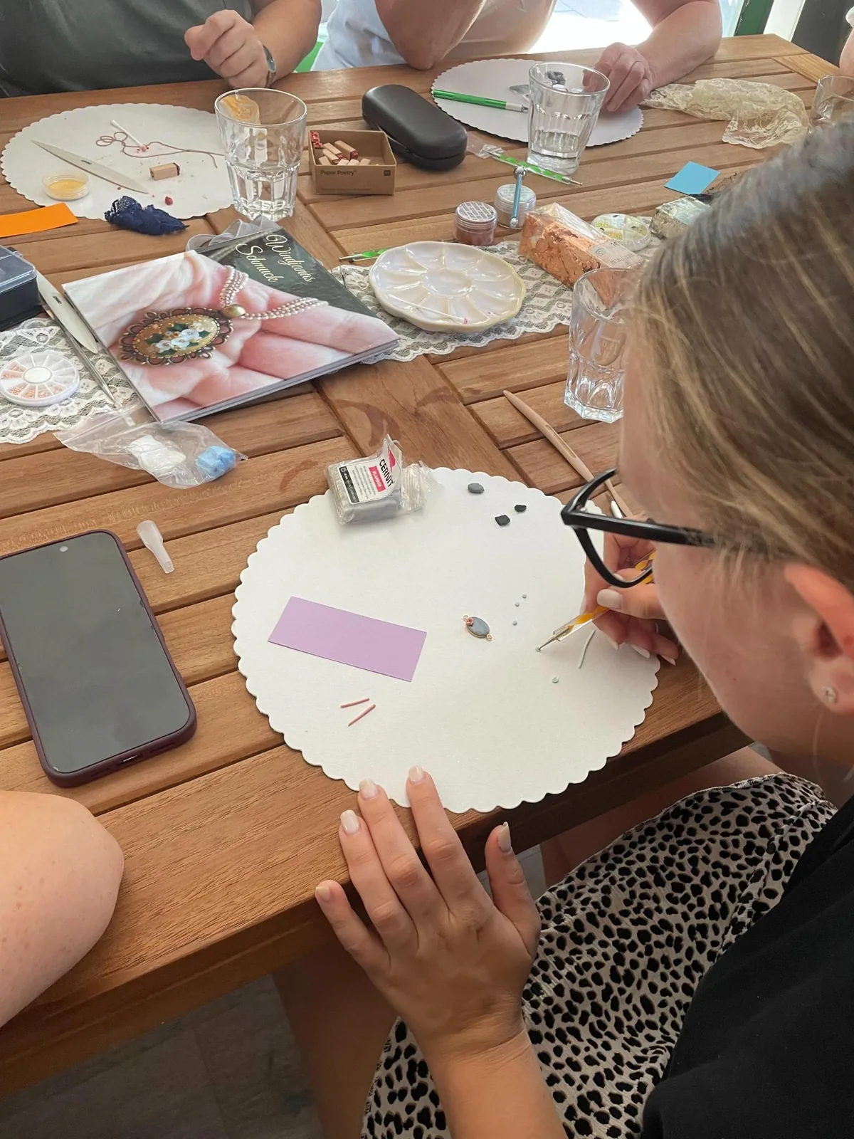 Teilnehmerin gestaltet im Workshop ein Schmuckstück aus Polymer Clay am Arbeitstisch
